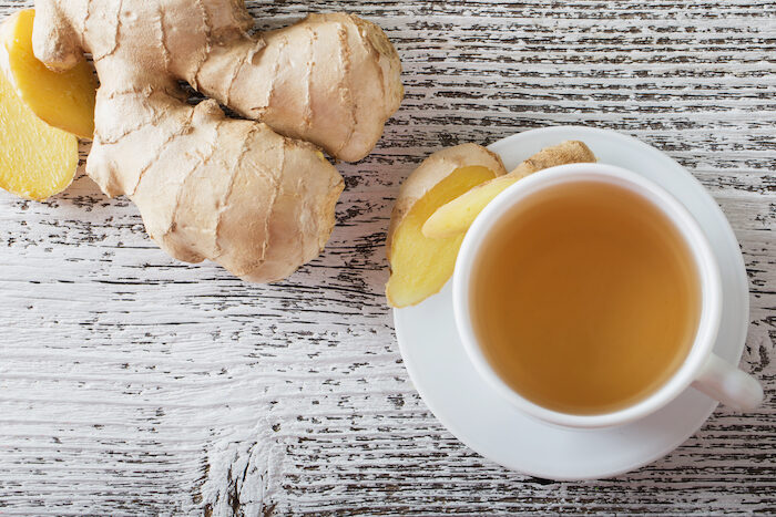ginger-tea-in-a-white-cup-on-wooden-background