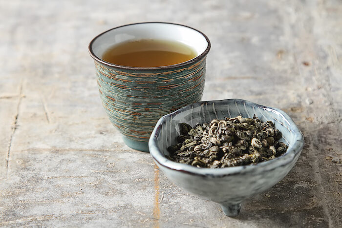 porcelain-chinese-cups-steel-teaspoon-black-green-puerh-oolong-tieguanyin-sencha-tea-gray-background
